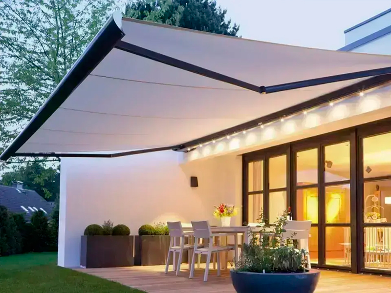 Toldo articulado protegendo uma varanda com mesa e cadeiras